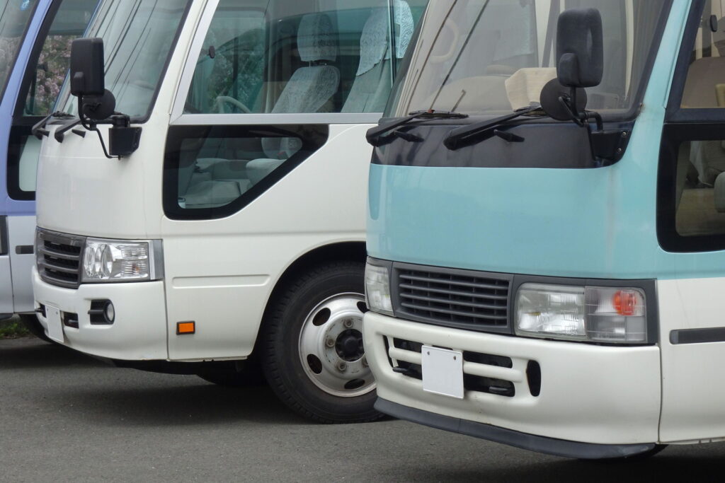 駐車場に停車している2台並んだ小型バス